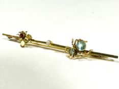 A Edwardian 9ct gold gem-set bug bar brooch, the knife-edge bar set centrally with a seed pearl