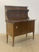 An Edwardian mahogany wash stand, the raised back with open shelf and inset with rouge marble panel,