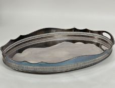A large Sheffield plated scalloped oval pierced gallery two handled drinks tray raised on bun
