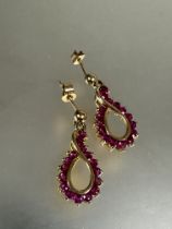 A pair of yellow metal figure of eight style drop earrings set fifteen round cut rubies, ( L x