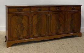A Reproduction Georgian style mahogany sideboard, fitted with four drawers over four panelled