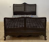 Heal's of London, an Edwardian carved mahogany and double bergere king size bed, the crest rail well