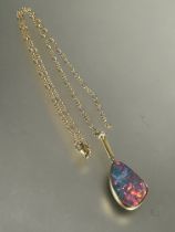 18ct gold mounted pendant set shaped black opal in rub-over setting, (L x 2.5cm x W x 1.5cm) with