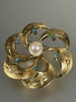A 1960's gold circular textured scrolling leaf shaped brooch set central cultured pearl and six