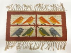 A flatweave woollen matt with tasselled edge repeating robin motif (62cm x 47cm)