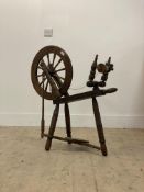 A stained and turned beech treadle spinning wheel of characteristic form H81cm