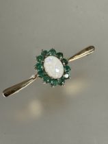 A 9ct gold water opal and emerald cluster set bar brooch, (L x 4cm x W x 1.5cm) 2.6g