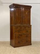 A Victorian mahogany linen press, the projecting cornice over two panelled doors enclosing three