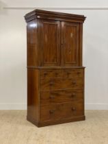 A Victorian mahogany linen press, the projecting cornice over two panelled doors enclosing three