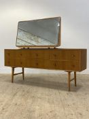 A mid century oak veneered dressing chest, the large swing mirror over six drawers, raised on
