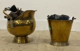 A brass coal scuttle with lion mask mounts and ceramic swing handle, together with another brass