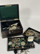 A Vintage black embossed jewellery box containing a collection of paste pearl necklaces radiating
