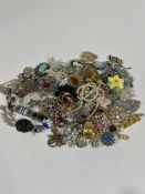 A collection of Vintage costume jewellery, including paste set brooches, hat pin, enamel fish