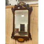 An early 20th century Georgian style mahogany fret cut wall hanging mirror, the frame with gilt ho-
