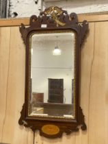 An early 20th century Georgian style mahogany fret cut wall hanging mirror, the frame with gilt ho-