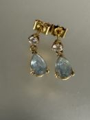 A pair of 18ct gold earrings, set with aquamarine pear shaped drops, 0.5ct in claw setting suspended