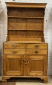 A Victorian pine dresser, the two height plate rack over four drawers and two panelled cupboards,
