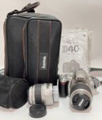 A Nikon D40 camera with two DX lens extensions and carry bag/manual