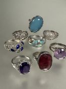 A collection of silver rings, two set, red dyed quartz, pale blue/green stone, two with lattice