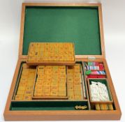 A boxed Mahjong set with amberine/plastic polymer counters, the interior with