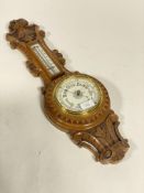 A Victorian oak aneroid barometer and thermometer in a banjo pattern case. H63cm