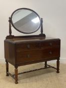 An early 20th century mahogany dressing chest of Neoclassical inspiration, the oval mirror above two