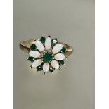 A 9ct gold opal and emerald floral cluster ring, the centre set emerald with surround of eight