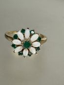 A 9ct gold opal and emerald floral cluster ring, the centre set emerald with surround of eight