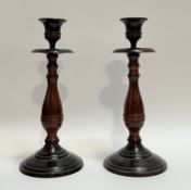 A pair of tompe l'eoil turned metal candlestick holders