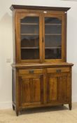 An early 20th century Arts and Crafts period oak bookcase cabinet, fitted with two glazed doors