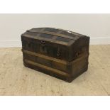 A late 19th century metal bound and leather covered dome top trunk, the hinged lid opening to a