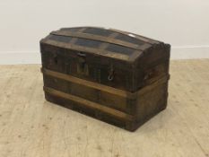 A late 19th century metal bound and leather covered dome top trunk, the hinged lid opening to a