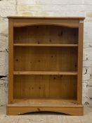 A polished pine open bookcase, fitted with two adjustable shelves, H110cm, W85cm