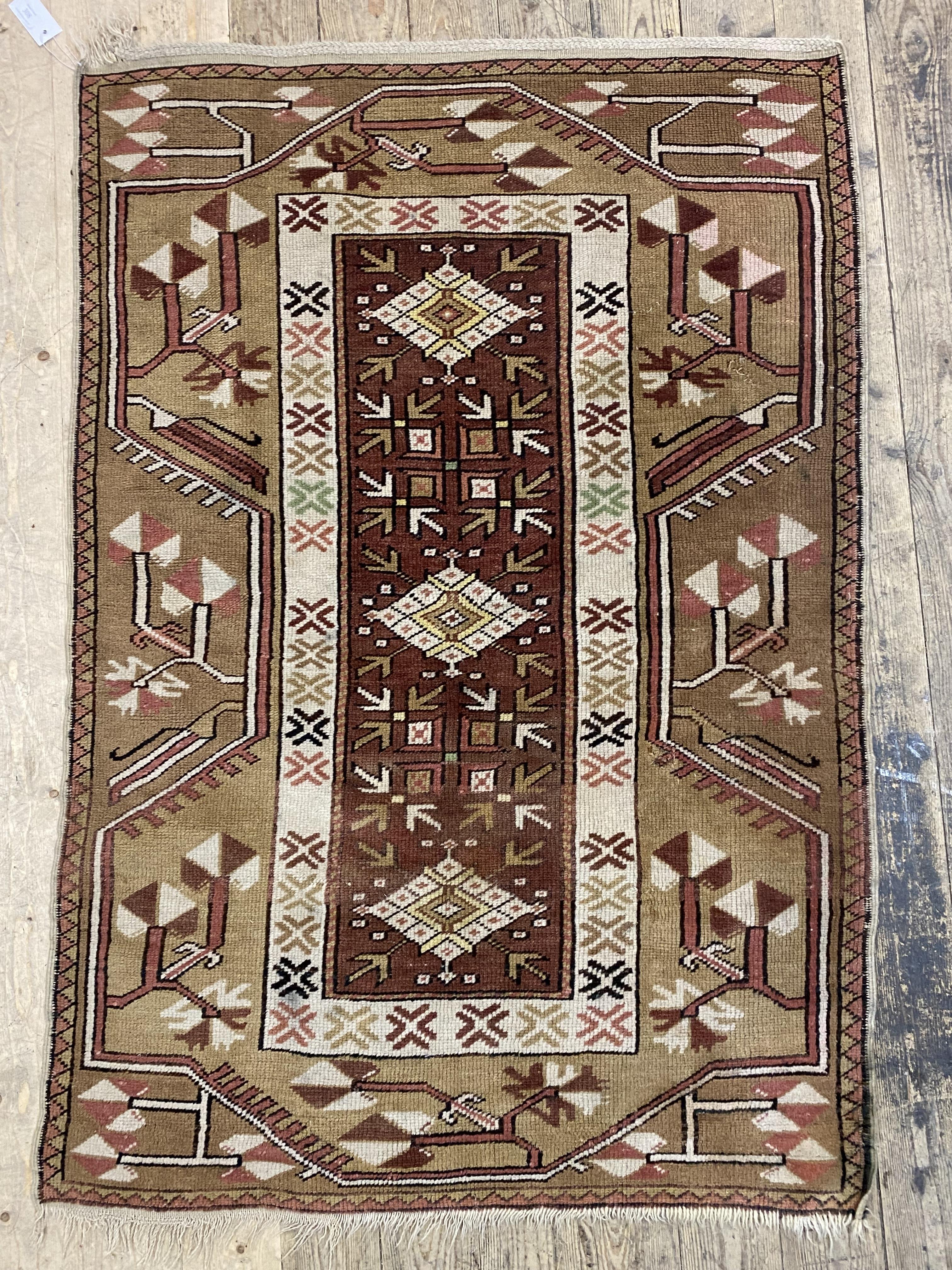 A hand knotted Turkish rug in a brown and red palette, of typical design 142cm x 96cm