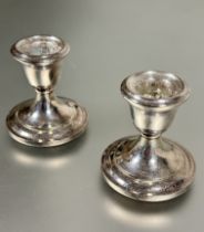 A pair of modern Birmingham silver desk style tapered candle sticks on circular weighted stepped