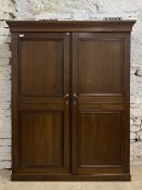 A large late 20th century stained pine and mahogany cupboard, the projecting cornice above two
