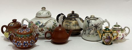 A group of miniature teapots comprising three Chinese Yixing redware teapots (two with enamelled dec