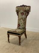 A Victorian walnut Prei dieu chair, the acanthus carved crest over back and seat upholstered in
