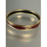 A gilt metal an dark rouge enamel stiff bangle with Groom a L'attante, made in Austria Hermes Paris,