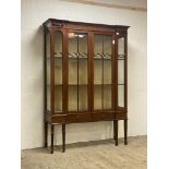 An Edwardian mahogany display cabinet, the frieze with applied carved torch motif above two
