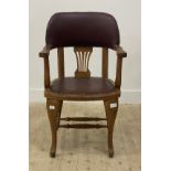 An early 20th century oak desk chair, the crest rail and seat upholstered in studded faux leather,