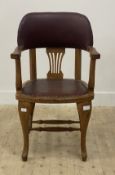 An early 20th century oak desk chair, the crest rail and seat upholstered in studded faux leather,