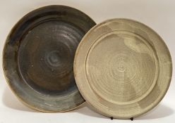 Two studio pottery dishes, the larger with dark glaze (marked verso) (w- 32cm), the other with white
