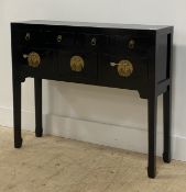 A Chinese style black lacquered side table, fitted with four drawers and three twin cupboard doors