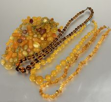 A vintage amber glass graduated bead necklace, (L x 27 cm), a natural amber nugget bead necklace, (L