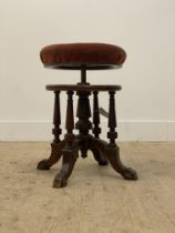 A Victorian walnut rise and fall piano stool, the circular seat upholstered in dusky red velvet,