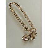 A 9ct gold kerb link chain bracelet with pig and heart charms and ring fastening, (D x 8 cm). 15.5g