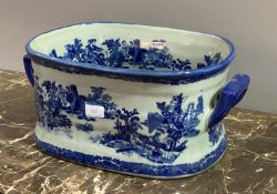 A Victorian style blue and white ceramic twin handled foot bath, decorated with romantic scenes