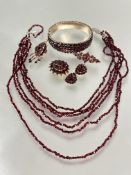 A suite of vintage garnet jewelry including a gilt metal graduated five row stiff hinged bangle, one