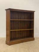 A late Victorian oak open bookcase, the rectangular moulded top above two adjustable shelves, raised